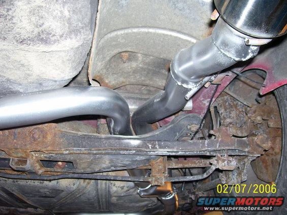 Underside view of a car's exhaust system, showing pipes and suspension components