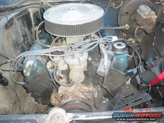 Engine bay of a 1979 Ford Bronco with a V8 engine, air cleaner, distributor, and brake fluid reservoir