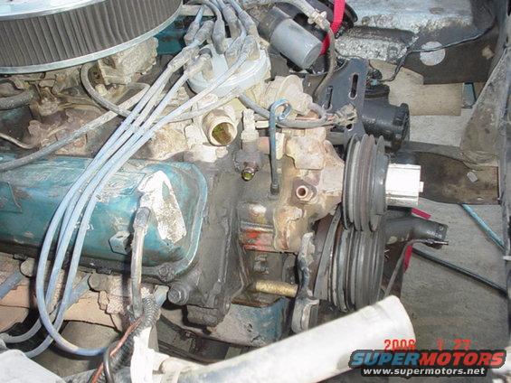 Engine compartment with distributor, spark plug wires, and pulleys visible