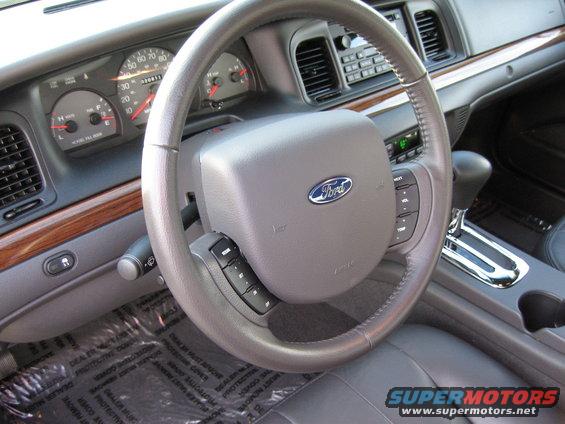 Interior of a 2005 Ford Crown Victoria showing the steering wheel, dashboard, and gear shifter
