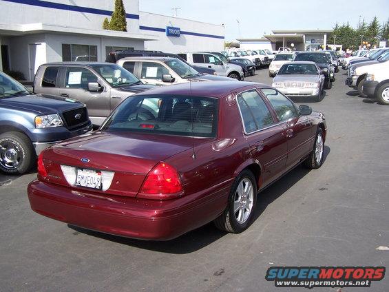 Maroon 2005 Ford Crown Victoria parked at a dealership with other vehicles
