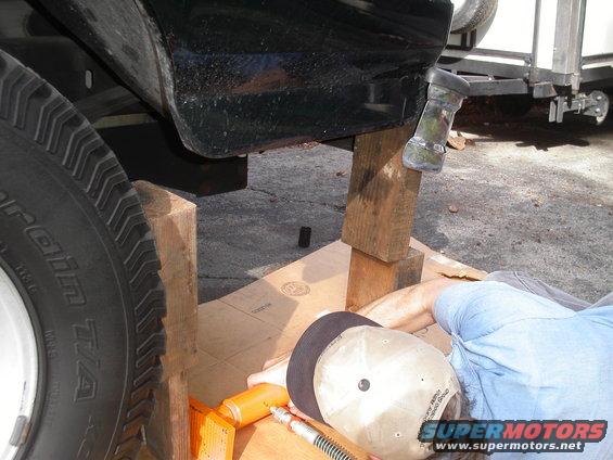 The day I bought the Bronco from my buddy Robin, he happened to back up into a big piece of plywood, pushing the rear bumper on the left side almost into the body. My friend Jim, is inspecting the bumper & getting ready to help me straighten it with his hydraulic jack.