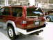 1996 Toyota 4Runner - Rear view of a red 1996 Toyota 4Runner Limited parked indoors, with another vehicle to its side.