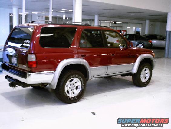 Red SUV parked inside, rear quarter view. It looks like a 1996 Toyota 4Runner