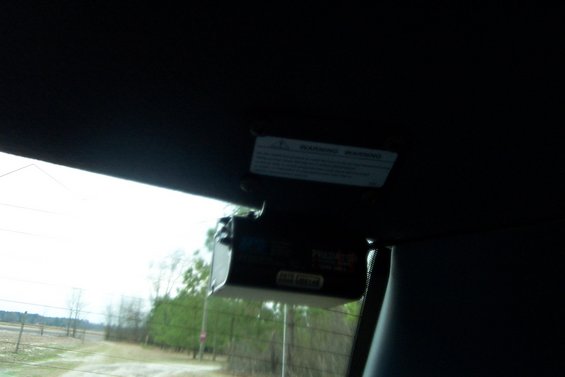 Interior view of a black electronic device attached to the rearview mirror