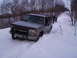 2000 Chevrolet Tahoe - Silver Chevrolet Tahoe and a black pickup truck on a snow-covered road in a wooded area.
