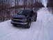 2000 Chevrolet Tahoe - A black Chevrolet Colorado pickup truck is parked on a snow-covered road surrounded by bare trees.