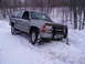 2000 Chevrolet Tahoe - This silver SUV appears to be stuck in a snowdrift, with a shovel leaning against the front bumper.