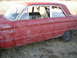 1963 Ford Falcon - Side view of a 1963 Ford Falcon sedan with faded red paint and visible primer.