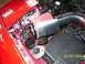 1994 Ford Probe - Close-up of a vehicle's engine bay, showing an aftermarket air intake system and fuse box.