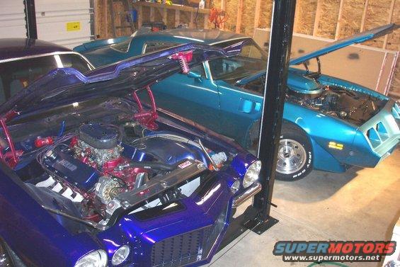 1979 Pontiac Trans Am and another muscle car in garage, hoods open