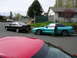 1996 Ford Probe - Two Ford Probes, a teal one with its door ajar and a black one, are parked on a suburban street.