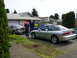 1996 Ford Probe - A group of people gathered around a silver 1996 Ford Probe and other vehicles in a residential driveway.