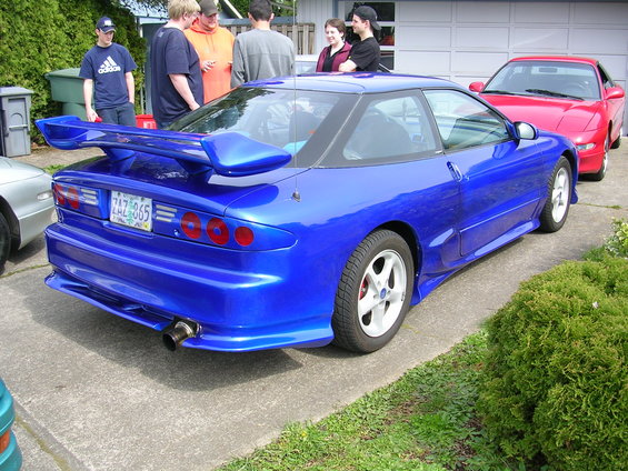 Blue sports coupe with a large rear spoiler and custom exhaust. License plate ZAZ 865