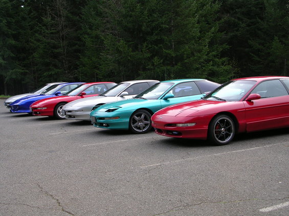 Red Ford Probe coupe parked in a line with other cars