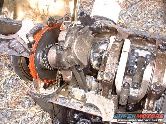 Damaged engine block with exposed crankshaft and connecting rods, showing signs of severe internal failure
