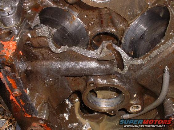 Close-up of a severely damaged cast iron engine block with broken sections and exposed cylinder bores