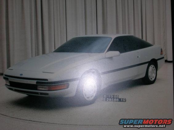 White coupe with a dark tinted roof and windows, seen from a 3/4 front angle