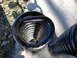 1979 Ford Bronco - A close-up view of a black coil spring, likely a suspension component, with visible yellow and blue markings.