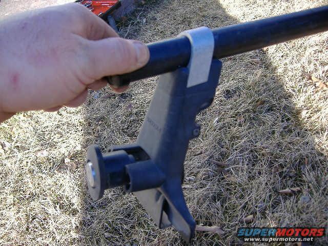 hand holding black roof rack component with metal strap