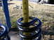 1979 Ford Bronco - A yellow measuring tape is used to measure the height of black coil springs.