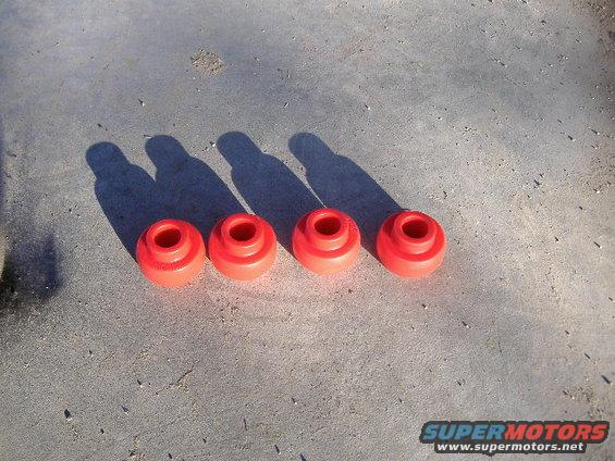 Four red suspension bushings on concrete