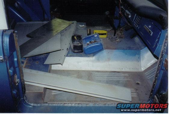 Blue vehicle interior with metal panels and containers on the floor
