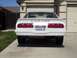 1978 Ford Mustang II - The rear of a white 1978 Ford Mustang II Cobra is shown parked in a driveway, distinctive horizontal louvers on the back window.