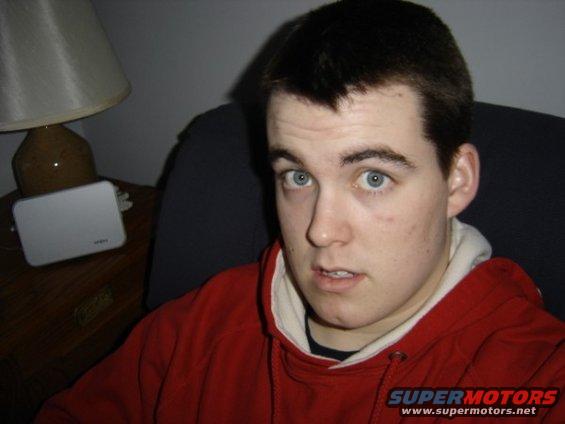Man in red hoodie, blue eyes, looking at camera