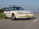 1993 Ford Mustang - A white 1993 Ford Mustang police car is seen from a three-quarter front view on a paved road.