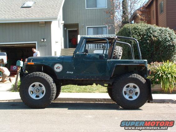 Green 1994 Jeep YJ Wrangler with aftermarket wheels and tires parked on a street