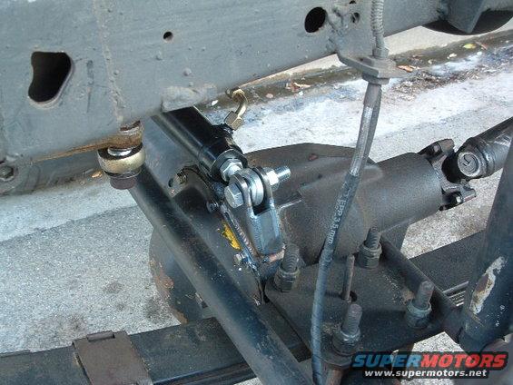 Close-up of a steering stabilizer mounted to a vehicle's differential and frame