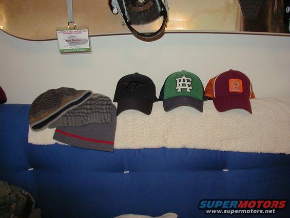Four hats and a snowboard with a name tag