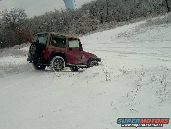 Red 1998 Jeep TJ in snow, 3q-front view