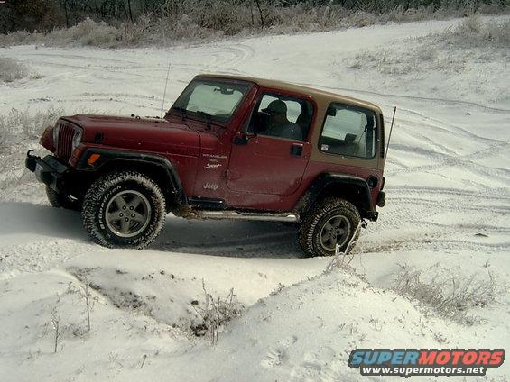 1998 Jeep TJ Wrangler driving in snow, red body with tan top