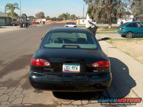 Black sedan parked on street, rear view. License plate 301-MYW. Contour GL badge visible