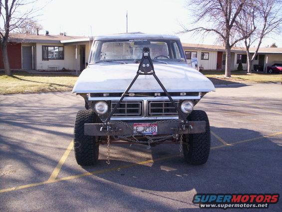 Front view of a white 1970s Ford pickup truck with a custom bumper and hood-mounted frame