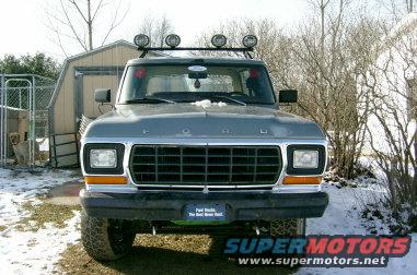 1979 Ford Bronco front view with roof lights and a shed in background