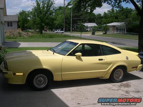 Yellow coupe with a fastback roofline parked on a concrete driveway