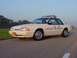 1993 Ford Mustang - A white 1993 Ford Mustang police car is parked on the side of a road under a clear sky.
