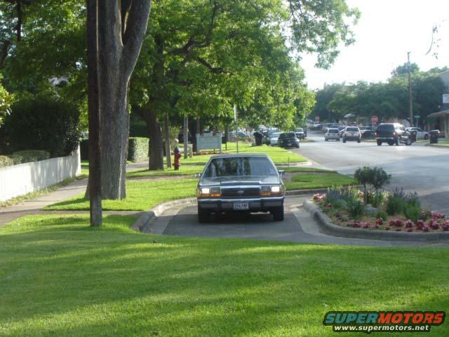 1988 Ford Crown Victoria LTD sedan, dark color, front view, parked on grass median