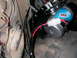 1984 Ford Bronco - Close-up of an ARB air compressor being installed, showing wiring and mounting hardware.