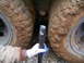2006 Ford F1 - A gloved hand holds a metal tool between two heavily mud-covered tires.