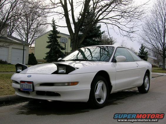 White 1997 Ford Probe with pop-up headlights parked on a residential street