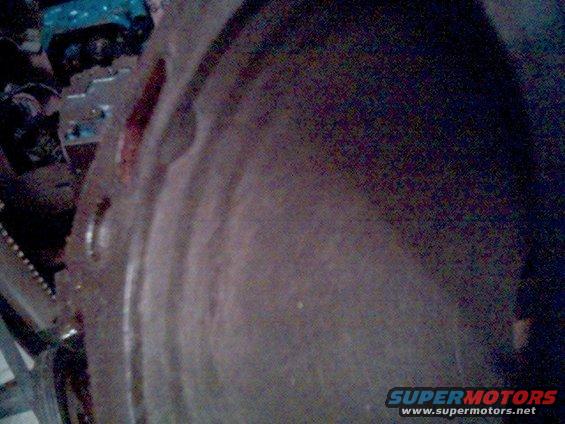 Close-up of a metal engine component with bolt holes