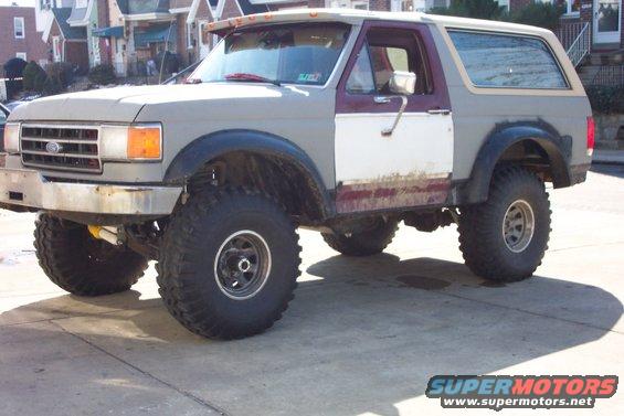 Gray and maroon lifted 1989 Ford Bronco with large tires