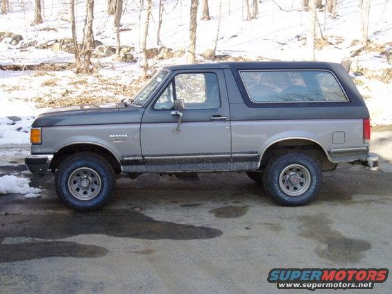 1988 Ford Bronco side profile. Two-tone gray and dark gray paint. Black hardtop