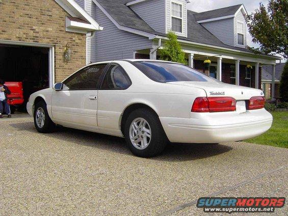 White 1996 Ford Thunderbird parked in driveway, rear 3/4 view