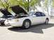 1996 Ford Thunderbird - A white 1996 Ford Thunderbird coupe is parked with its hood open, alongside another vehicle.