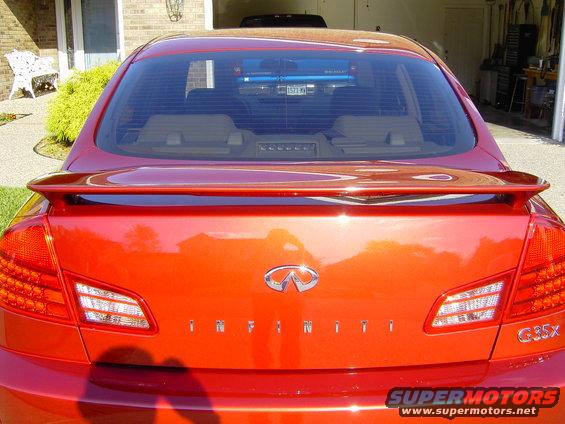 Red Infiniti G35x sedan rear view with spoiler and tinted windows
